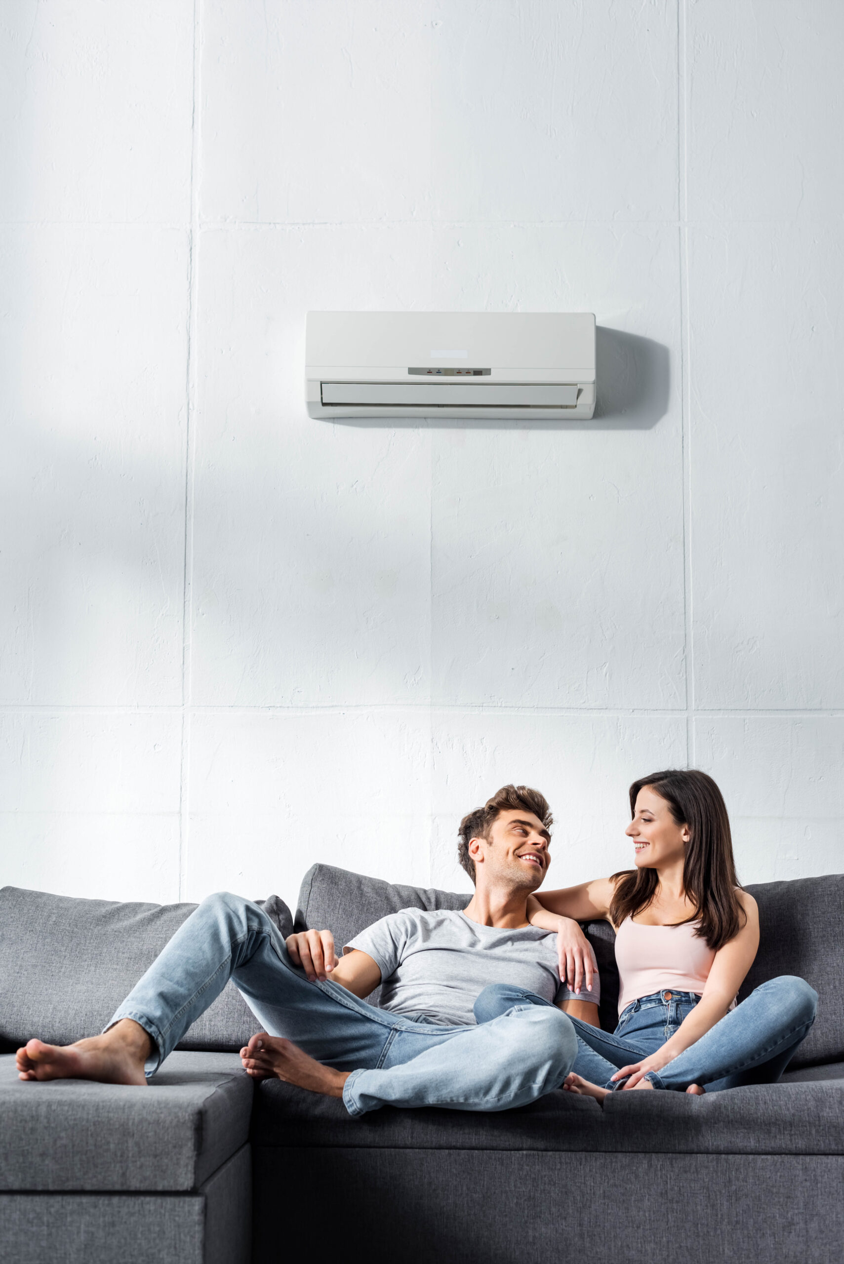 attractive girlfriend and handsome boyfriend smiling and sitting on sofa